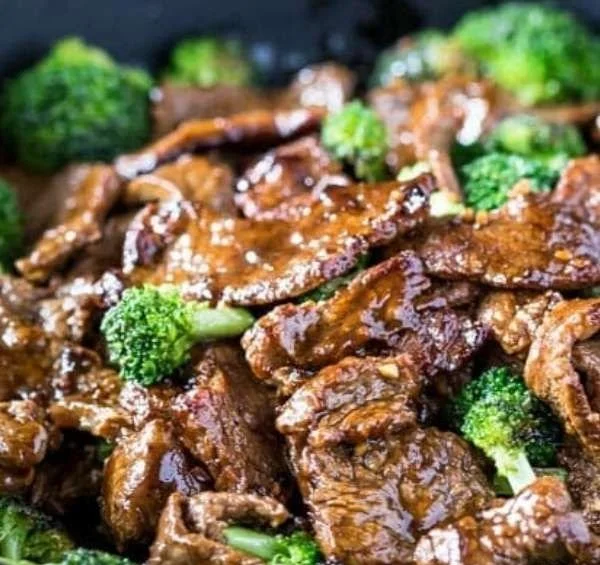 Beef and broccoli stir fry with colorful vegetables in a skillet