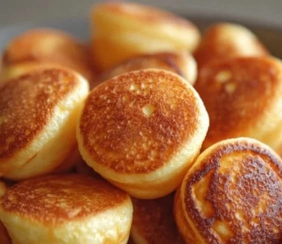 Delicious breakfast pancake poppers served on a plate with syrup and berries.