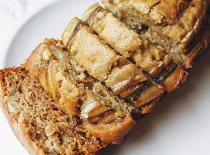 A freshly baked classic banana bread loaf with sliced bananas and walnuts