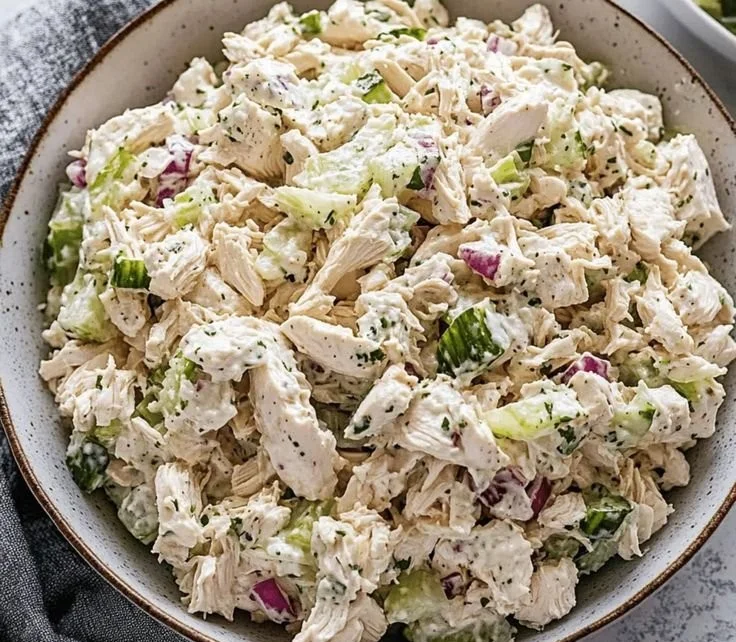 Delicious classic chicken salad served in a bowl with fresh vegetables.