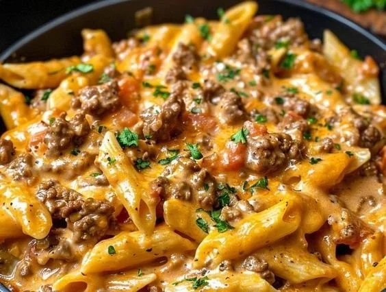 Creamy beef pasta served in a bowl with herbs and cheese