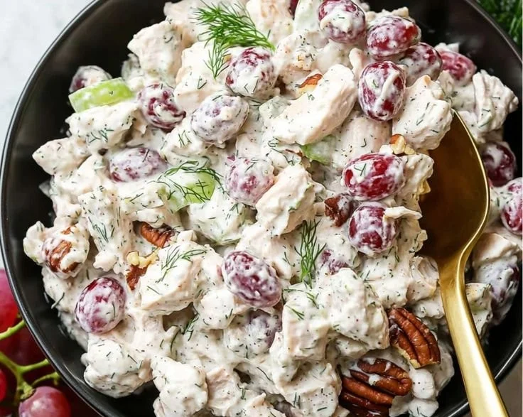Delicious easy chicken salad served in a bowl with fresh vegetables and herbs.