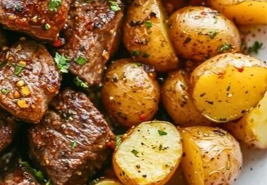 Delicious garlic steak bites served with roasted potatoes