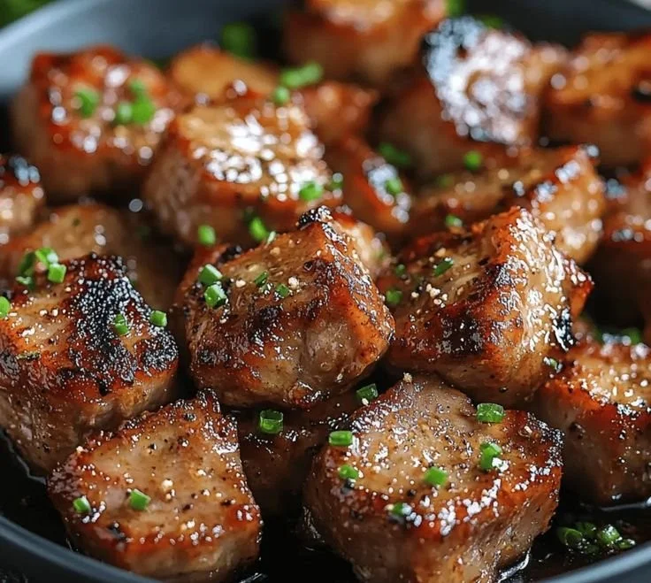 Savory garlic pork bites served on a platter, showcasing their delicious flavor.