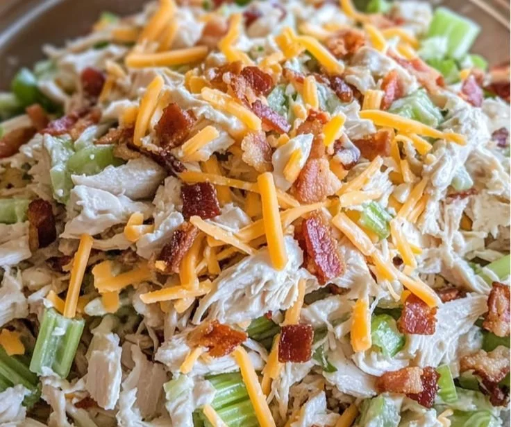 Bowl of Million Dollar Chicken Salad garnished with herbs.