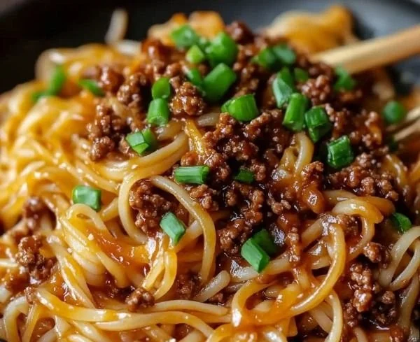 Mongolian ground beef noodles served in a bowl with fresh vegetables
